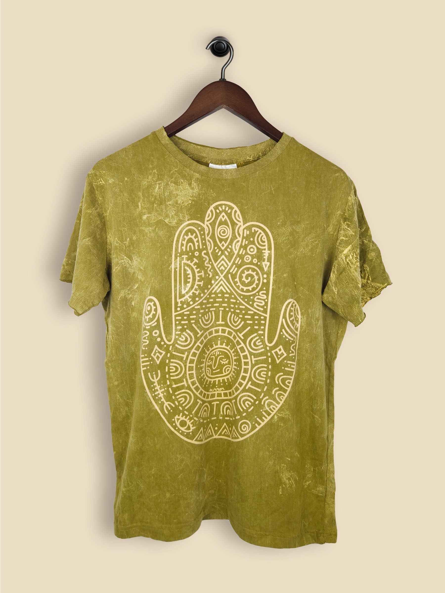 A khaki t-shirt featuring a print of a hamsa hand with geometric patterning