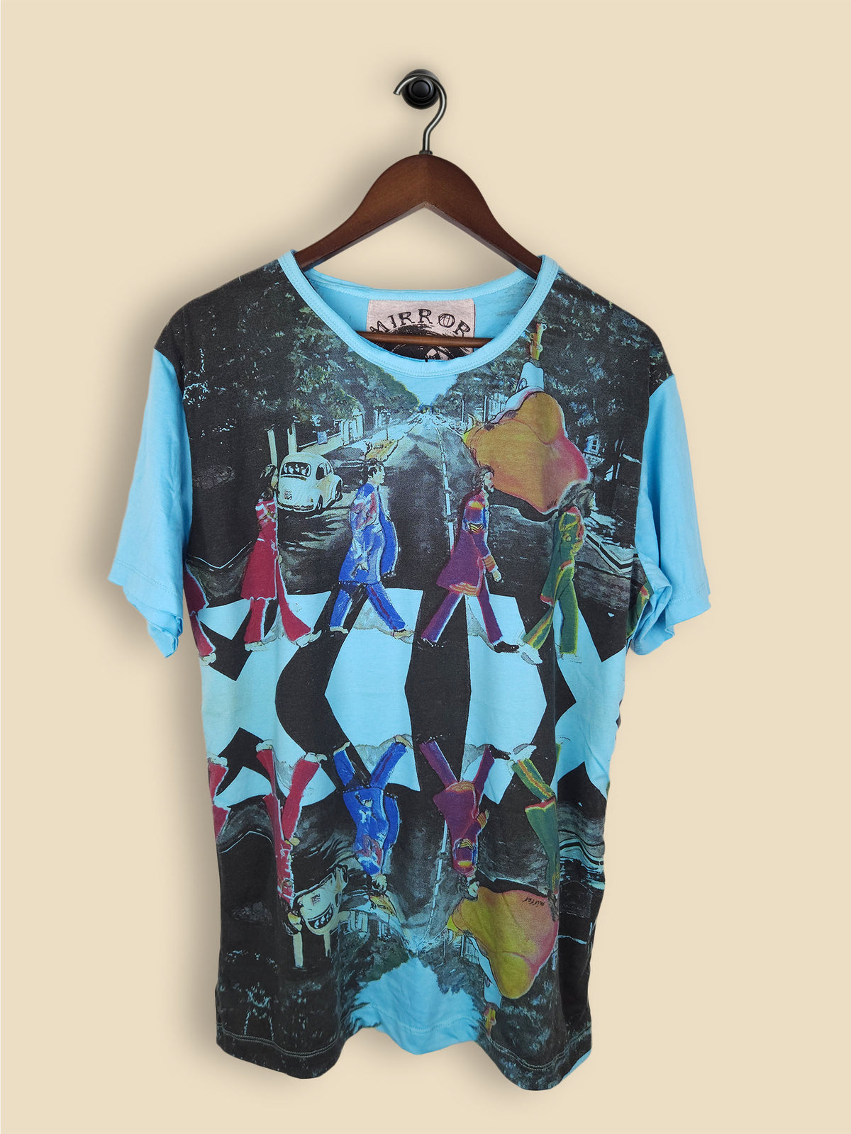A blue T-shirt featuring a colorful, artistic reinterpretation of the iconic Abbey Road album cover by The Beatles.