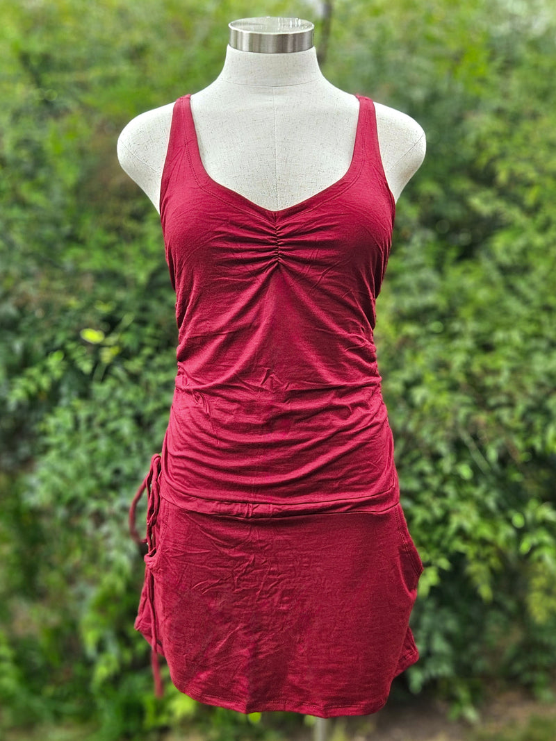 Red dress on a mannequin against a green leafy background