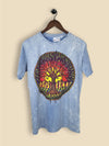 A light blue stonewashed T-shirt with a colourful tree of life design featuring a vibrant sunset