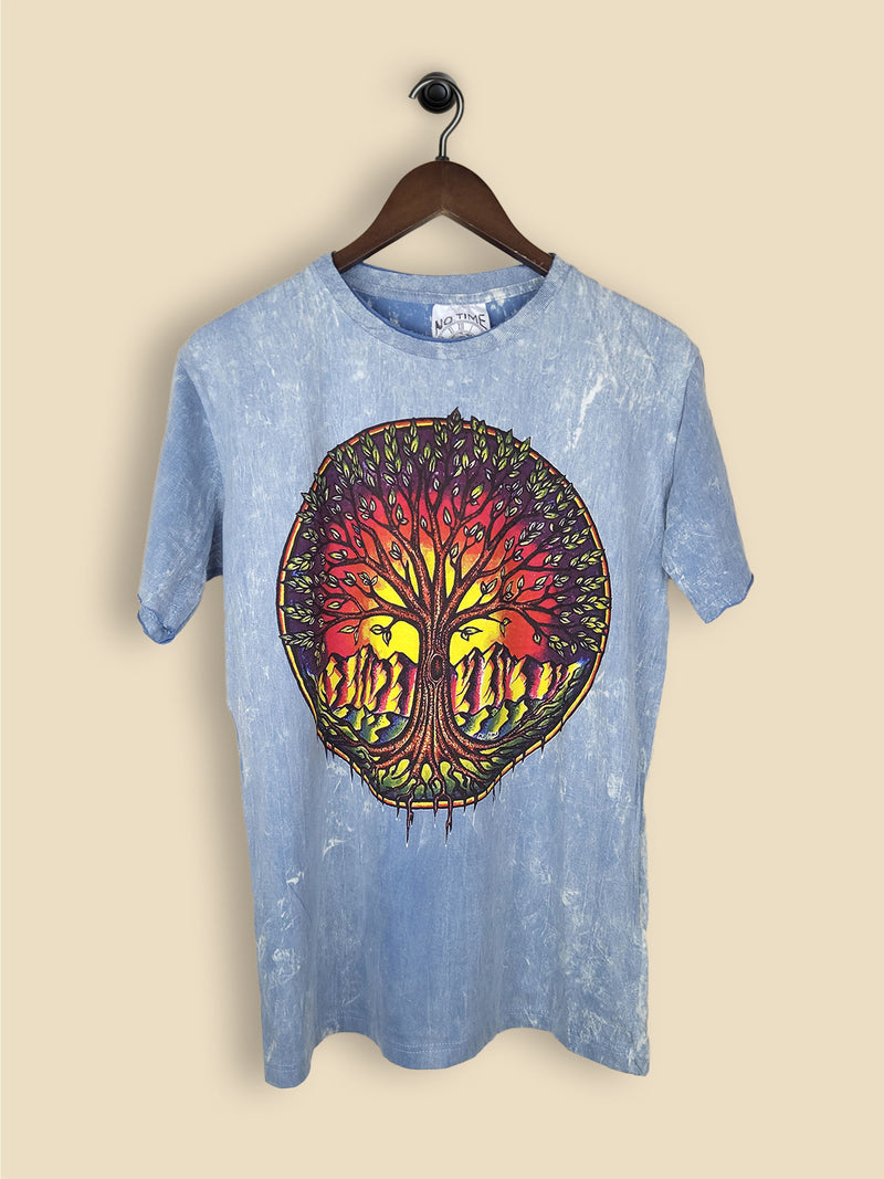 A light blue stonewashed T-shirt with a colourful tree of life design featuring a vibrant sunset