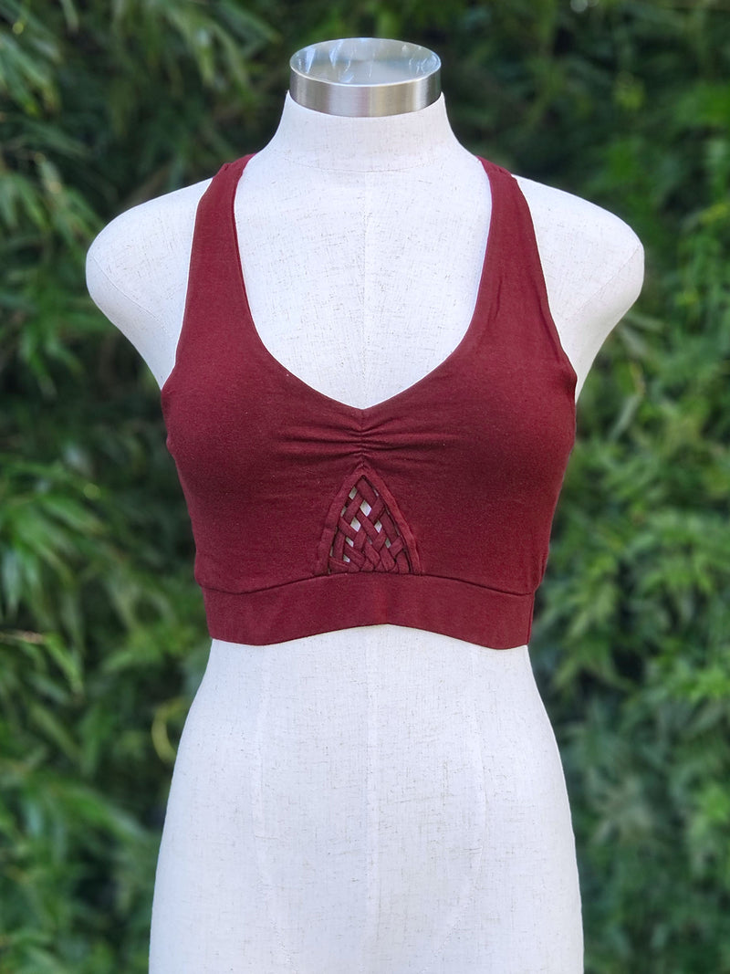 Red crop top on a mannequin with a green leafy background