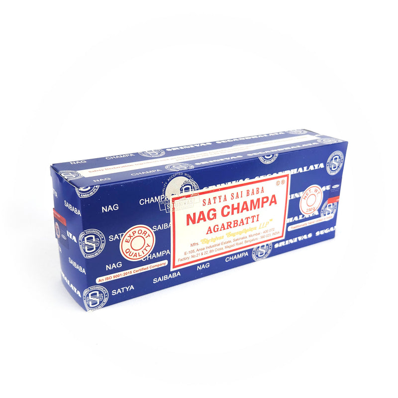 A rectangular blue box of Satya Sai Baba Nag Champa Agarbatti incense sticks is shown prominently. The box features a detailed red and white label with the text 'Satya Sai Baba Nag Champa Agarbatti,' 'Export Quality,' and 'Net Wt. 250g.' The packaging includes manufacturing details and certifications, highlighting its high quality and authenticity. This image captures the well-known and cherished design of the Satya Sai Baba Nag Champa incense, recognized for its distinctive fragrance and premium quality.