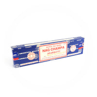 A rectangular blue box of Satya Sai Baba Nag Champa Agarbatti incense sticks is shown prominently. The box features a detailed red and white label with the text 'Satya Sai Baba Nag Champa Agarbatti,' 'Export Quality,' and 'Net Wt. 40g.' The packaging includes manufacturing details and certifications, highlighting its high quality and authenticity. This image captures the well-known and cherished design of the Satya Sai Baba Nag Champa incense, recognized for its distinctive fragrance and premium quality.