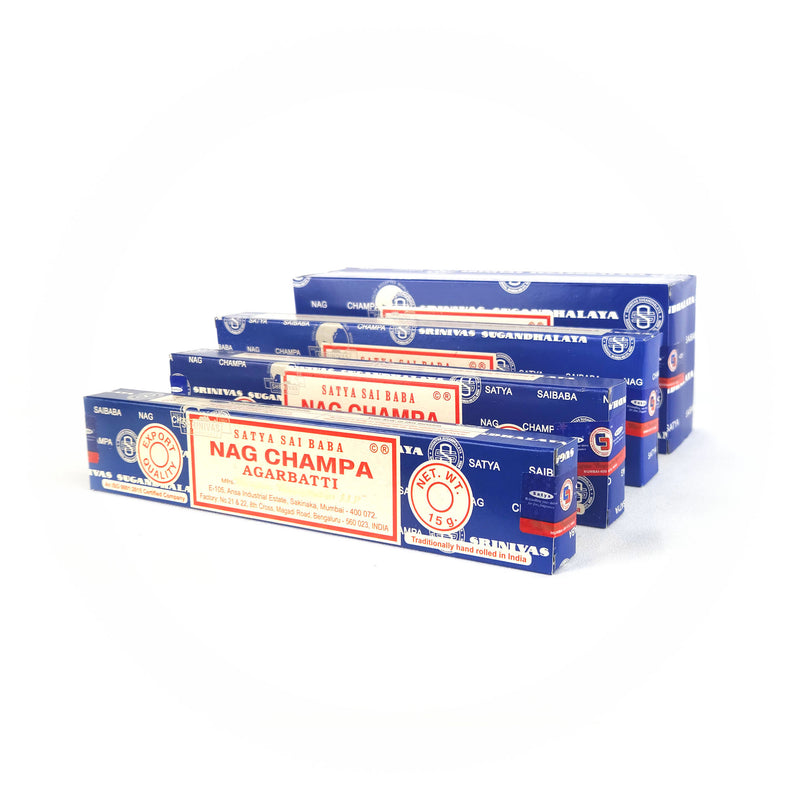 Several boxes of Satya Sai Baba Nag Champa Agarbatti incense sticks, stacked together. The blue boxes have red and white labels with the brand name, product name, and weight of 15 - 250 grams. The packaging emphasizes traditional hand-rolled incense made in India.