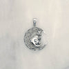 Front shot of sterling silver pendant of a cat with a pentagram collar sitting on a crescent moon with celtic pattern