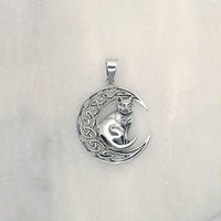Front shot of sterling silver pendant of a cat with a pentagram collar sitting on a crescent moon with celtic pattern